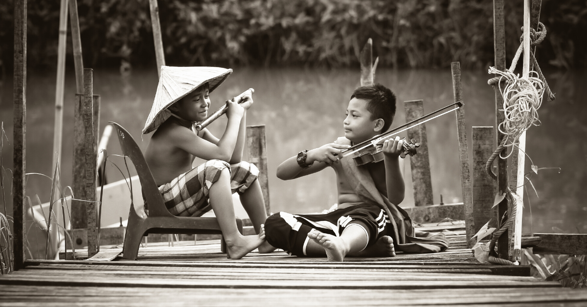 Children playing with instruments sat next to each other